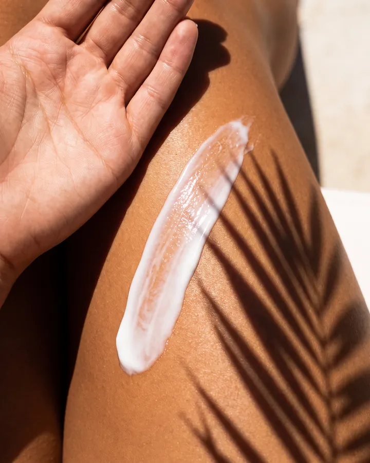 A stripe of body cream on a shoulder in palm shade